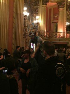 A stilt walker interacting with a spectator at the Los Angeles Theater
